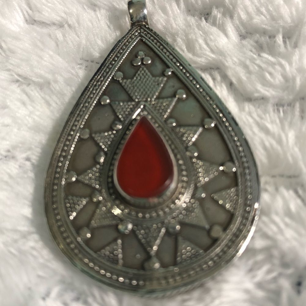 Pendant, silver color with red accent. 2”.